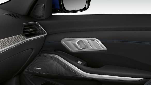 Close-up of the inner passenger door illuminated with built-in speaker of the Harman Kardon surround sound system.