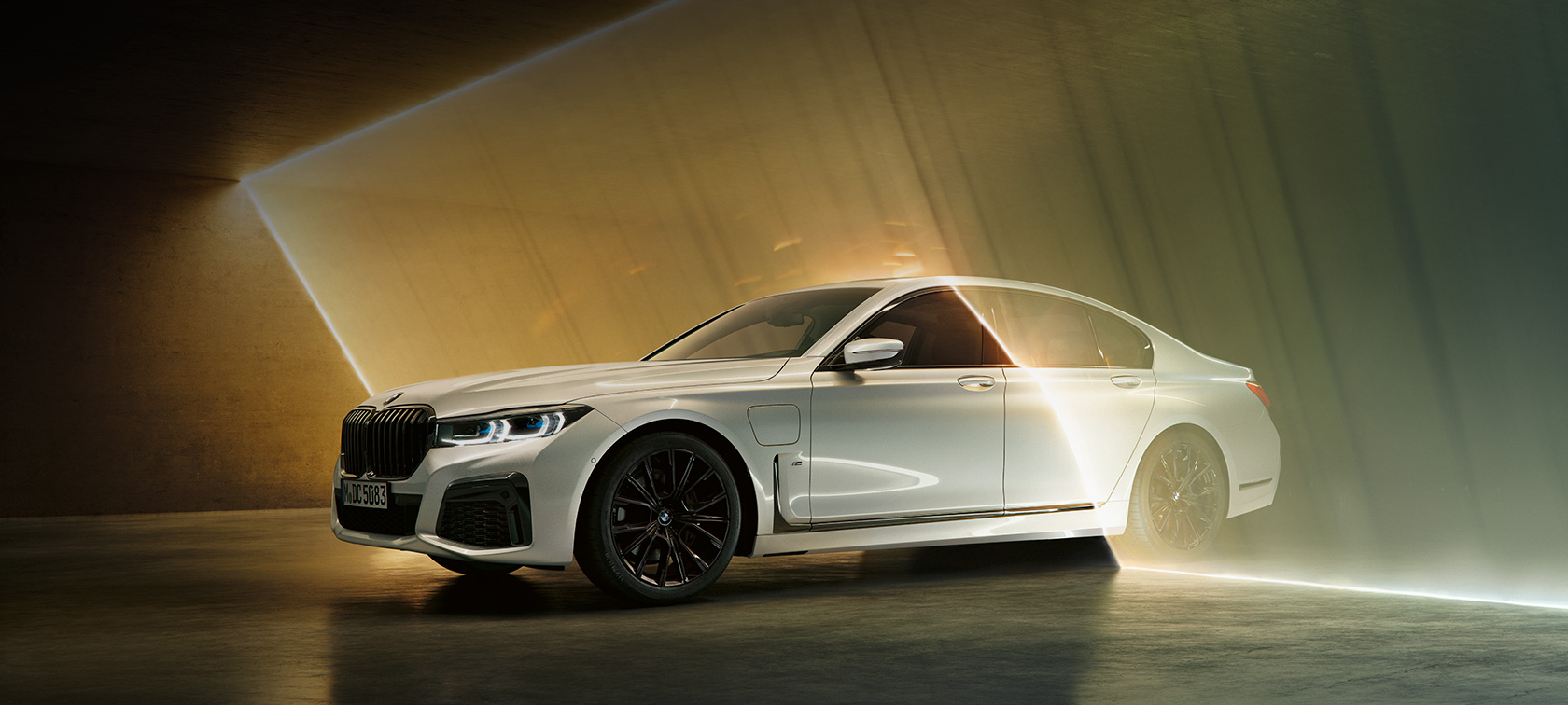 BMW 7 Series Sedan: white BMW in three-quarter front view surrounded by beam of light