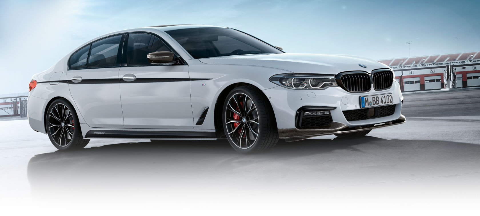 Side view of the BMW 3 Series Sedan on a parking lot with blue sky.